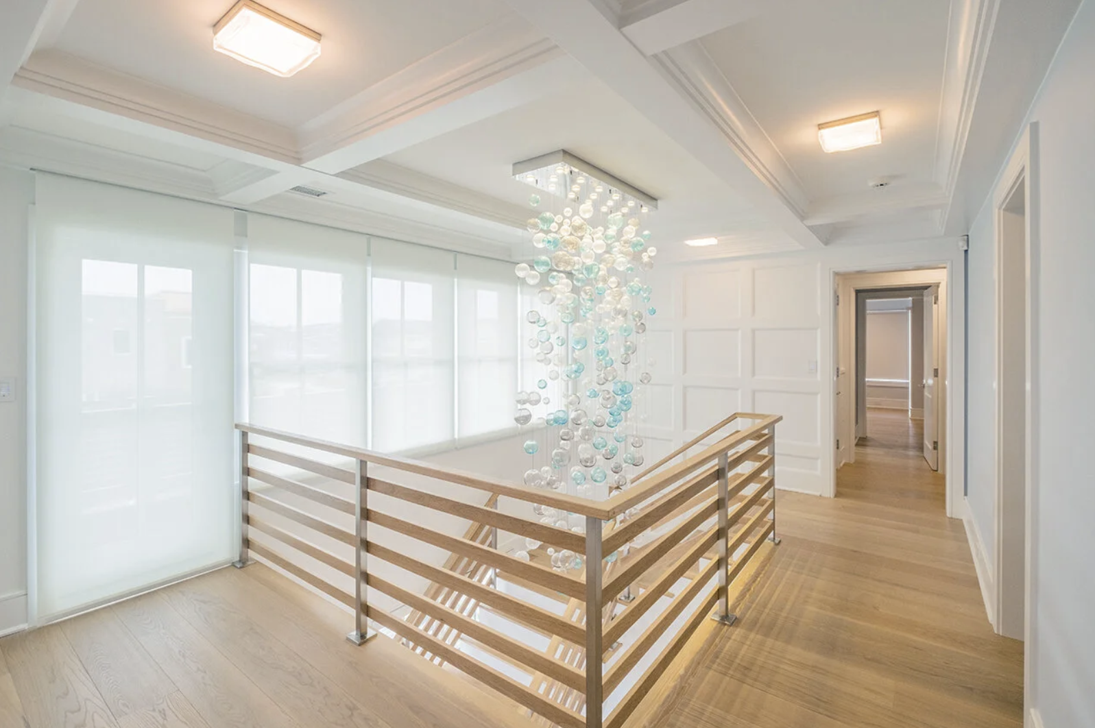 Lutron HomeWorks lighting control in a modern hallway with architectural lighting and motorized shades